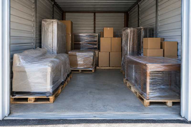 Box de stockage rempli de mobilier filmé sur palettes